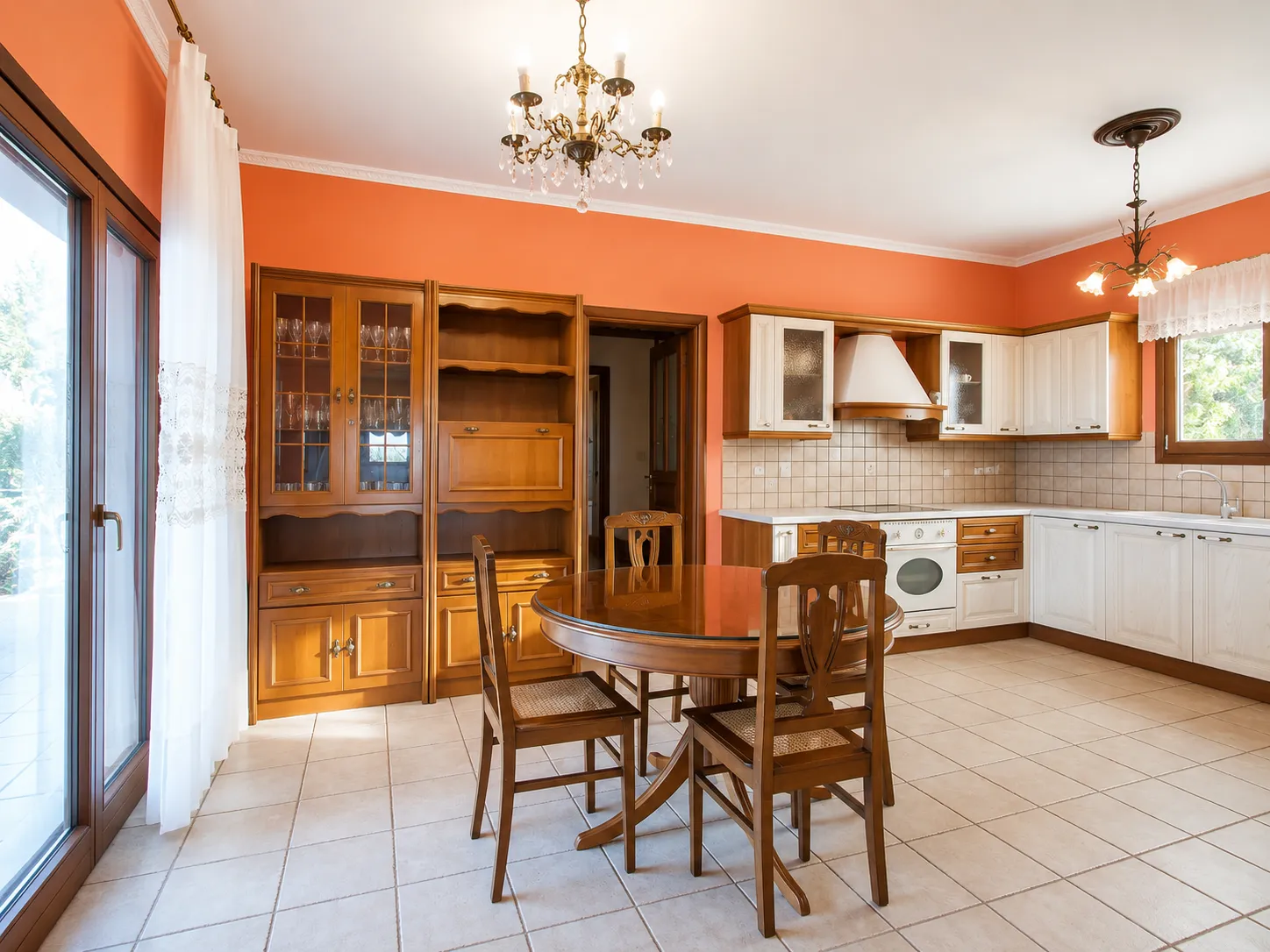 Country kitchen with dining table, display cabinet and terrace door at Villa Viktoria, Skiathos