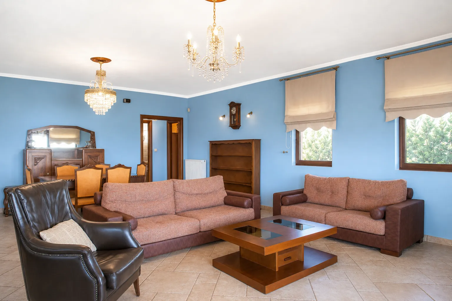 Living room with sofas, leather armchair and crystal chandeliers at Villa Viktoria, Skiathos