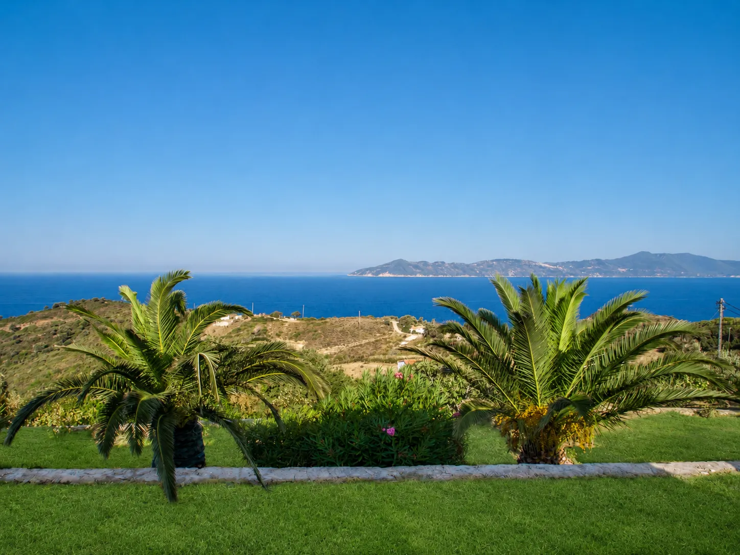 Daytime panoramic view of the Aegean Sea and offshore island from Villa Viktoria gardens