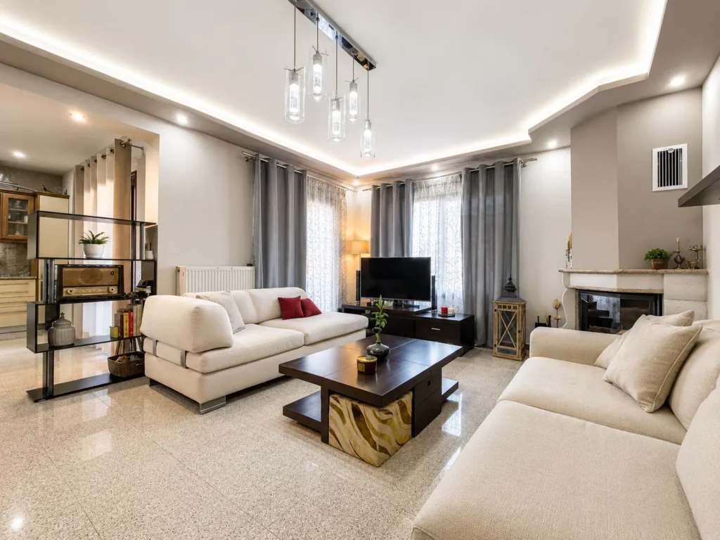 Top-floor lounge with two sofas, display shelving and fireplace, The Triple Threat, Skiathos